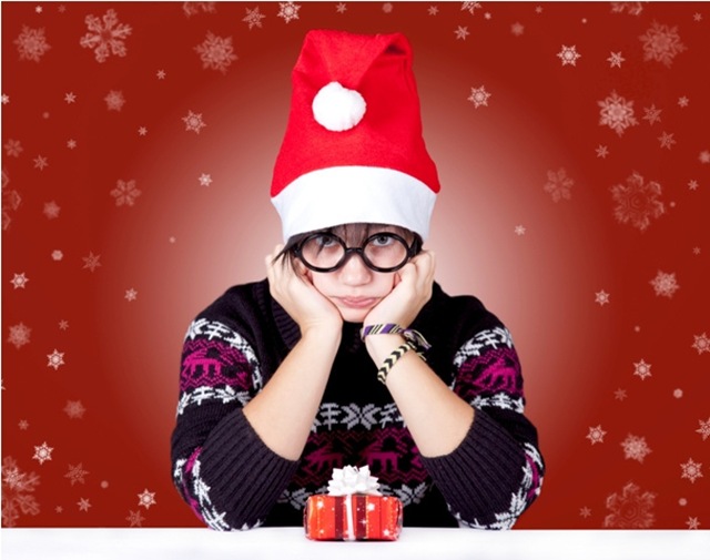Funny girl in glasses with christmas gifts.